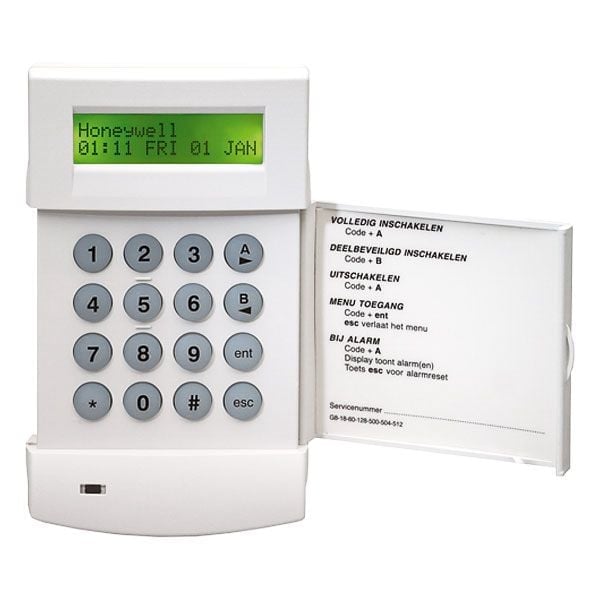 Vintage alarm system keypad with green LCD display showing time and date, numeric buttons 0-9, and instruction manual card beside it